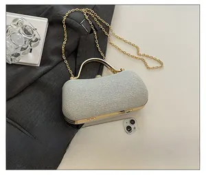 Silver sequin evening clutch with gold metal handle and rhinestone clasp shown with phone