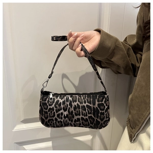 Close-up of leopard print shoulder bag featuring top zipper and silver metal hardware