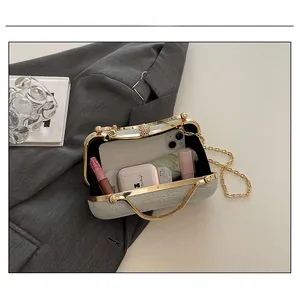 Detailed view showing the capacity of the silver glitter evening clutch with chain strap