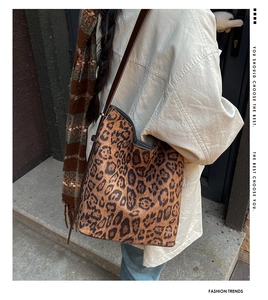 Close-up of leopard print tote bag with suede texture and dark brown leather shoulder strap