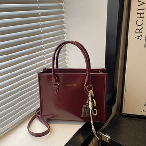 Sac à main carré rétro rouge foncé avec lettres dorées et breloque chocolat sur rebord