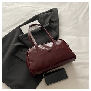 Close-up of burgundy faux leather handbag featuring a practical front snap pocket