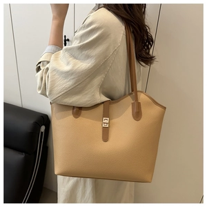Detail of lychee pattern leather tote bag with silver buckle and dark brown shoulder strap