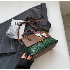 Detail of green woven leather base and brown flap with golden buckle and silk scarf