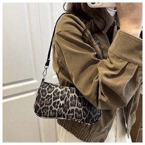 Close-up of leopard print baguette bag with leather texture and silver buckle