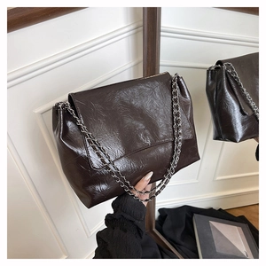 Détail du sac à bandoulière en cuir froissé café avec bandoulière chaîne argentée