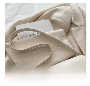 Detail shot of the comfortable leather shoulder strap on a beige vintage square bag