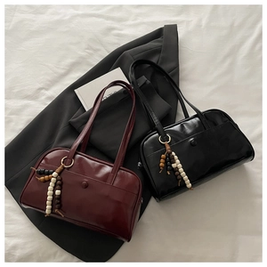 Close-up of vintage Boston bags in burgundy and black with decorative beaded tassels