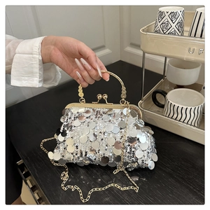 Detailed view of silver sequin evening bag with gold metal handle and chain strap