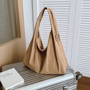 Large camel casual tote bag for travel and commute, displayed on a silver suitcase