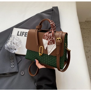 Detail of vintage tote bag featuring brown leather, green texture, and silk scarf handle