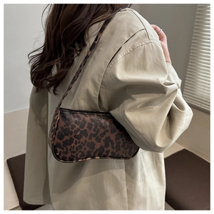 Detail shot of leopard print underarm bag worn by model showing trendy retro style