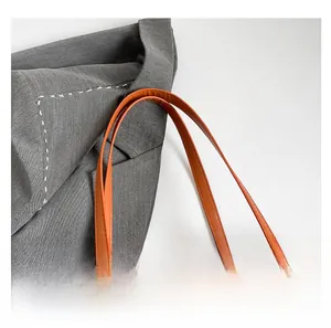 Detail of checkered tote bag showing orange leather knotted handle and stitching