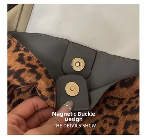 Detail view of the secure magnetic buckle on a leopard print suede tote bag