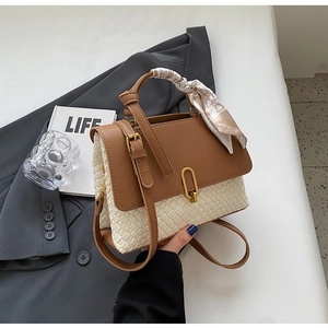 Detail of color-block tote bag with woven texture, golden U-lock and silk scarf handle wrap