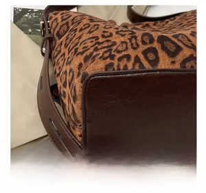Detailed view of reinforced stitching and leopard print fabric on a stylish tote bag