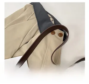 Detail of leopard print tote bag with brown leather strap over a beige trench coat