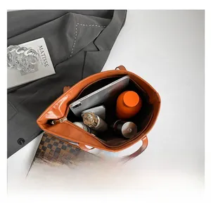 Top-down view of a spacious orange tote bag showing internal storage for tablets and bottles