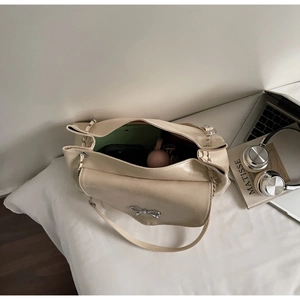 Interior detail of creamy tote bag with silver bow buckle and practical storage space