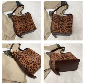 Detail view of large leopard print suede tote bag with brown leather base and strap