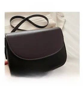 Detail of a deep brown and black crossbody bag with embossed Fashion Bags logo