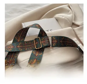 Close-up of wide geometric woven shoulder strap with gold hardware and leather details