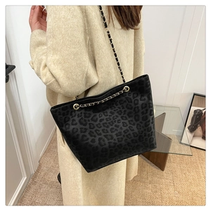 Detail of trendy leopard print tote bag with gold chain strap and textured fabric finish