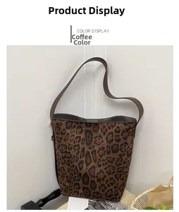Detail of leopard print bucket bag with brown strap on a rustic decorative background