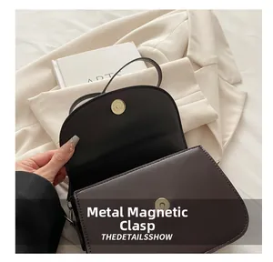 Close-up of premium light gold magnetic snap closure on vintage brown leather handbag