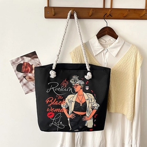 Classic black canvas tote bag with graphic print and rope handles in a home setting