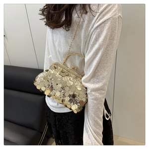 Detail of shimmering gold sequins on shell-shaped evening bag with metal chain strap