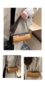 Close-up of suede cylinder bag featuring fashion gold lettering and ethnic print strap
