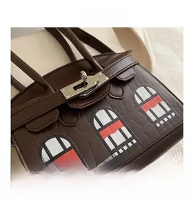 Detail of dark brown faux-crocodile leather handbag with architecture window pattern