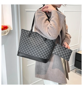 Detail of checkered tote bag set with black leather straps and matching pouch