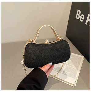 Detail of black sequin evening clutch with gold handle and sparkling clasp
