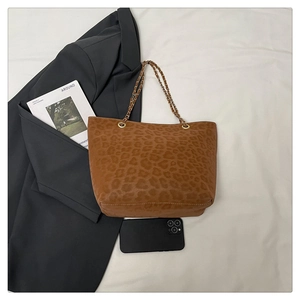 Détail du sac cabas imprimé léopard avec chaîne dorée et finition en daim texturé