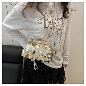 Detail of elegant gold sequin clutch bag with vintage metal clasp and chain strap