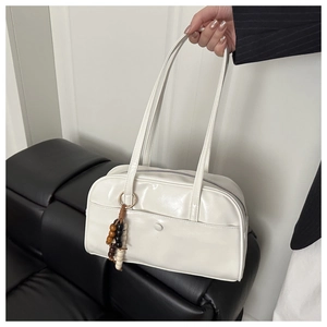 Detail of white glossy PU leather shoulder bag with decorative wooden beads and front pocket