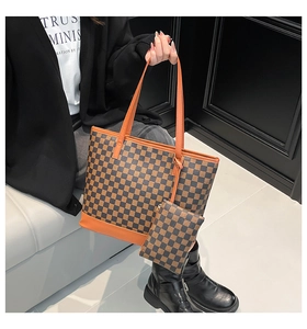 Detail of checkered tote bag with orange leather trim and matching zip pouch set
