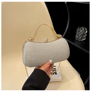 Detail of silver glitter evening clutch with gold metal handle and crystal clasp closure