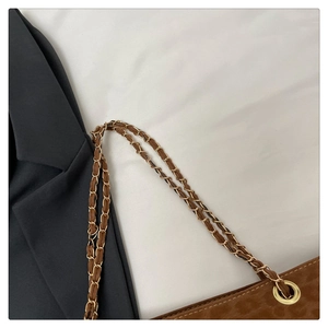 Détail de la bandoulière chaîne dorée et texture du sac léopard marron à œillets