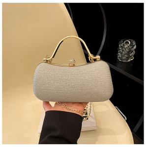 Detail of champagne gold evening bag with rhinestone clasp and metal round handle