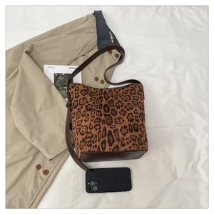 Top-down view of leopard print bucket bag with brown leather base and adjustable strap