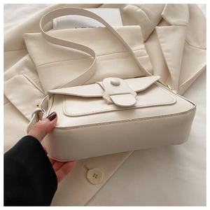 Gros plan d'un sac à bandoulière en cuir crème avec boucle ton sur ton élégante et moderne