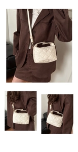 Close-up of heart quilted stitching detail on a beige faux leather bucket handbag