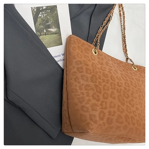 Gros plan du sac fourre-tout léopard avec chaîne dorée sur un blazer gris