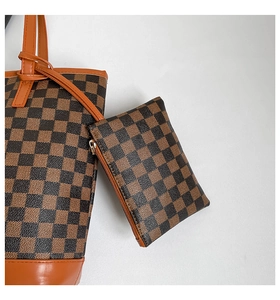 Close-up of checkerboard tote bag with matching pouch and brown leather details