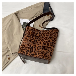 Detail of leopard print tote bag with brown leather strap on a stylish lifestyle setting