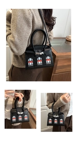 Detail of black crocodile texture handbag with unique mini house window patchwork design