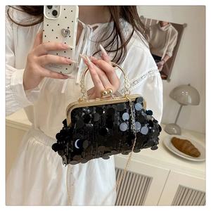 Mirror selfie showing the black sequin evening bag with elegant pearl handle